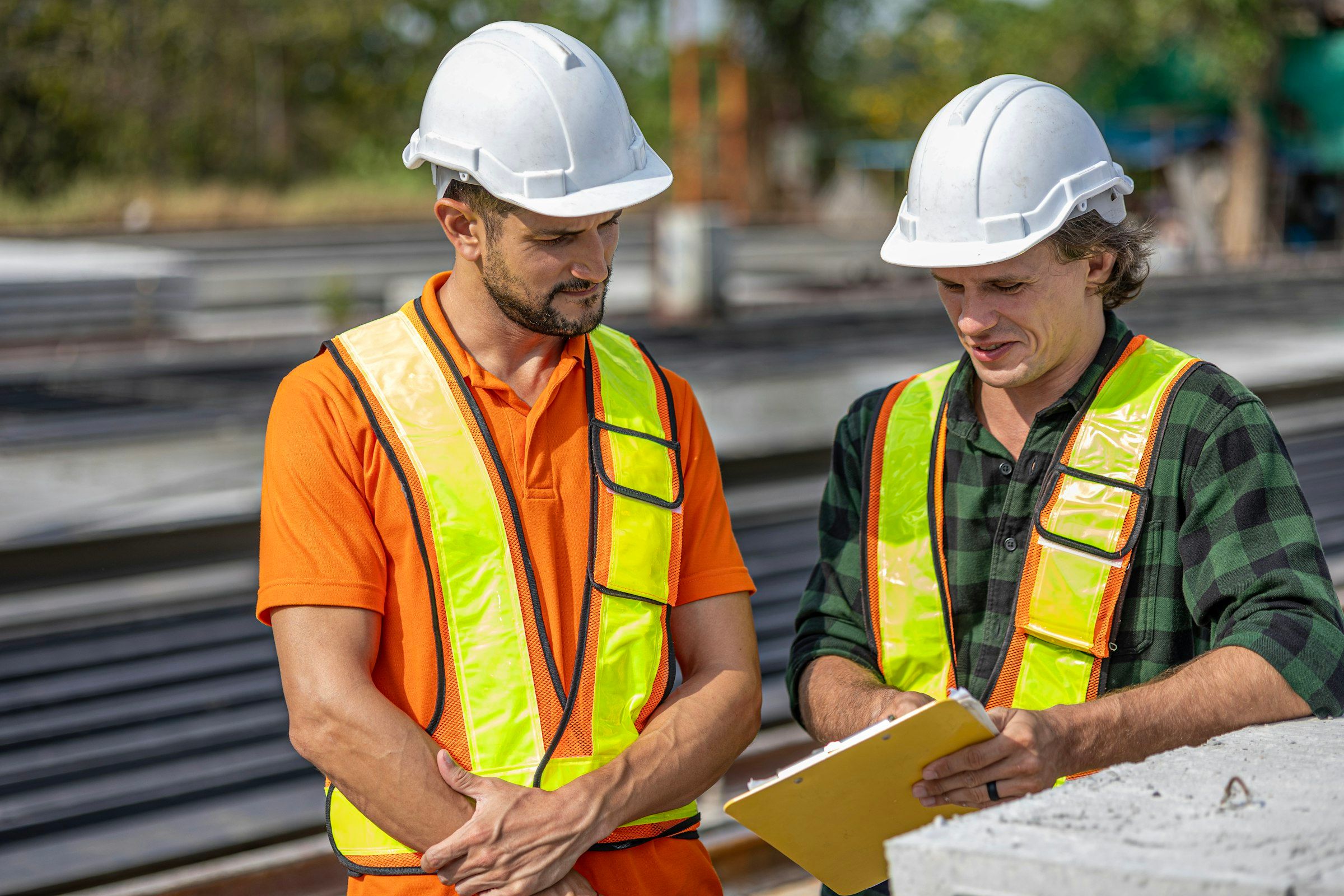 Zwei Bauleiter prüfen Pläne auf der Baustelle